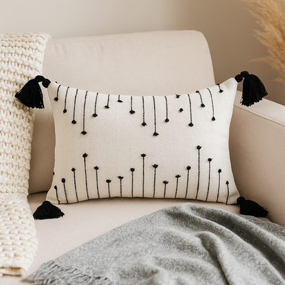 Coussin blanc a broderies noires et pompoms