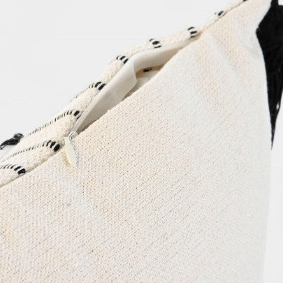 Coussin blanc a broderies noires et pompoms