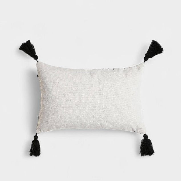 Coussin blanc a broderies noires et pompoms