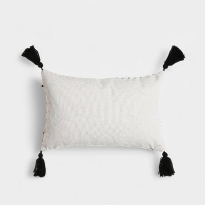 Coussin blanc a broderies noires et pompoms