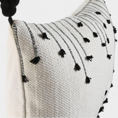 Coussin blanc a broderies noires et pompoms
